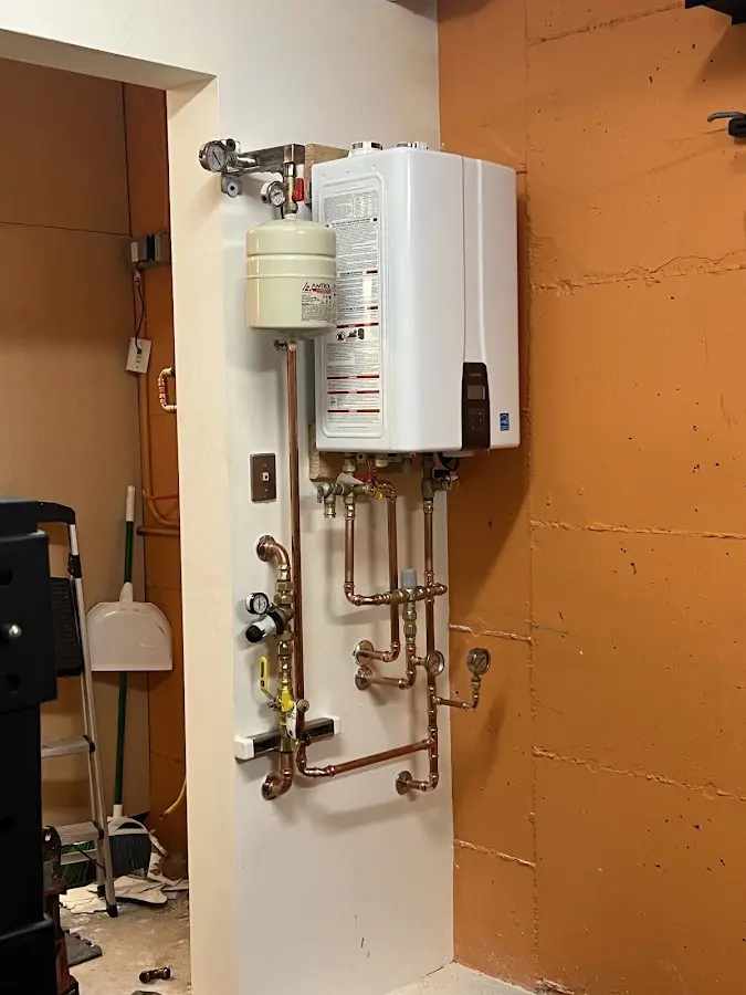 Plumbing technician inspecting water heater connections in Parksdale